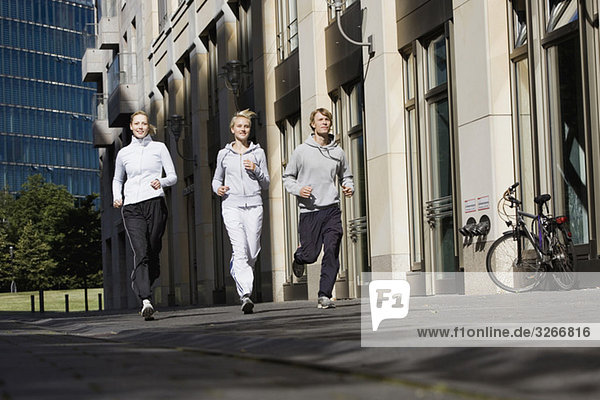 Germany  Berlin  Three friends jogging together