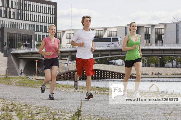 Deutschland  Berlin  Drei Freunde joggen in der Stadt