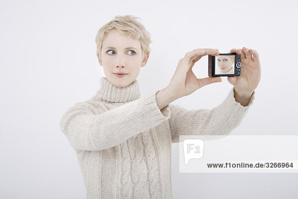 Woman taking a self-portrait with digital camera