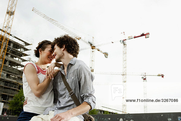 Deutschland  Berlin  Junges Paar vor dem Neubau  Krane im Hintergrund