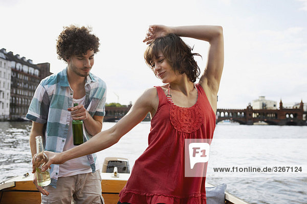 Junges Paar auf dem Motorboot  Mann sieht Frau tanzen  Porträt
