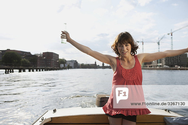 Junge Frau auf Motorboot  Arme ausgestreckt