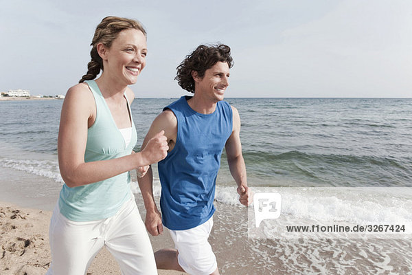 Spain  Mallorca  Couple jogging across beach