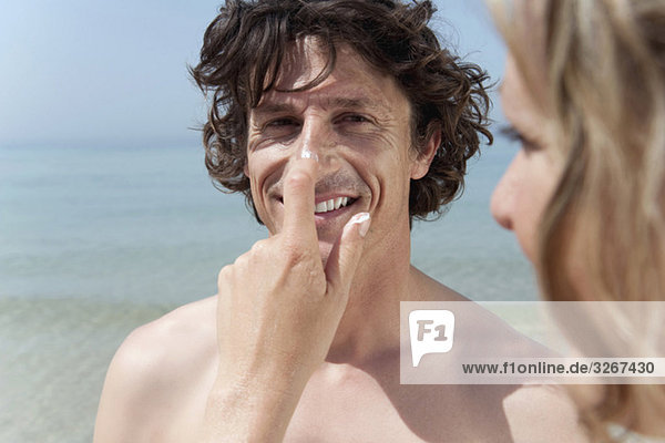 Spanien  Mallorca  Frau mit Sonnencreme auf der Nase des Mannes