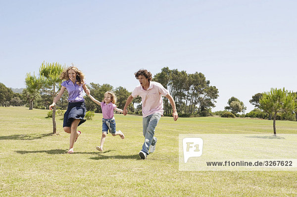 Spain  Mallorca  Family running across meadow