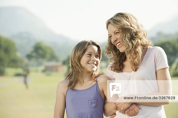Spain  Mallorca  Mother and daughter (10-11) arm in arm  smiling  portrait  close-up