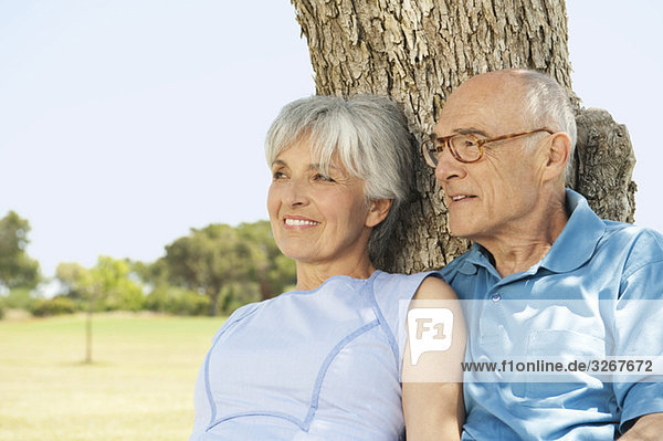 Spanien  Mallorca  Seniorenpaar am Baum sitzend  entspannend