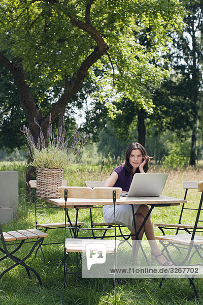Woman using laptop in garden
