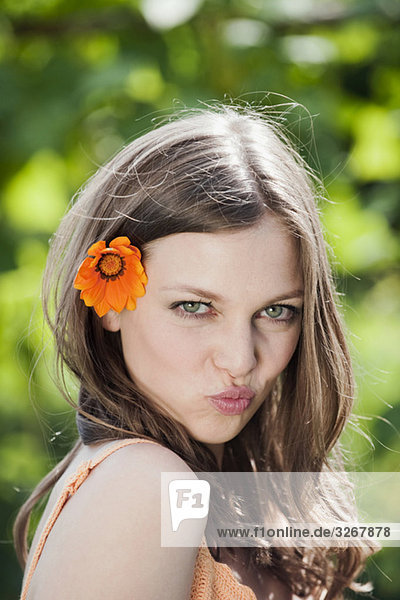 Woman with flower in hair  pouting lips  portrait  close-up