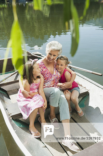 Italy  South Tyrol  Grandmother and grandchildren (6-7) (8-9) sitting in rowing boat  elevated view  portrait