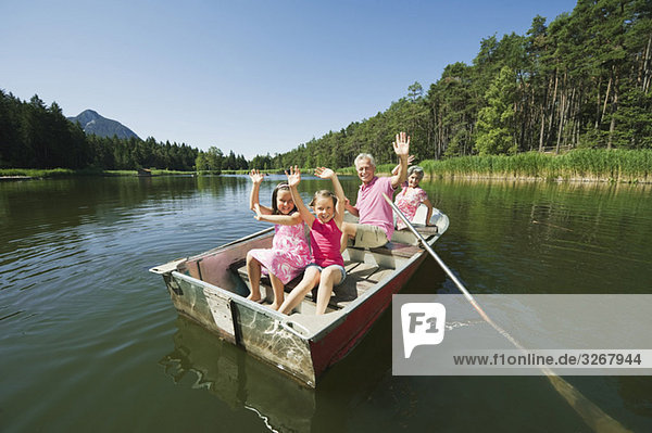 Italy  South Tyrol  Grandparents and children (6-7) (8-9) in rowing boat on lake  portrait
