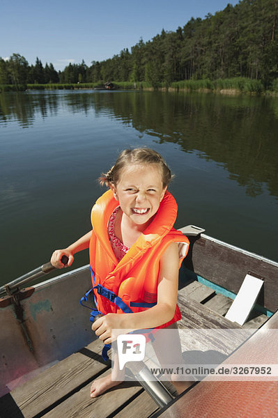 Italy  South Tyrol  Girl (6-7) standing in rowing boat  smiling  portrait