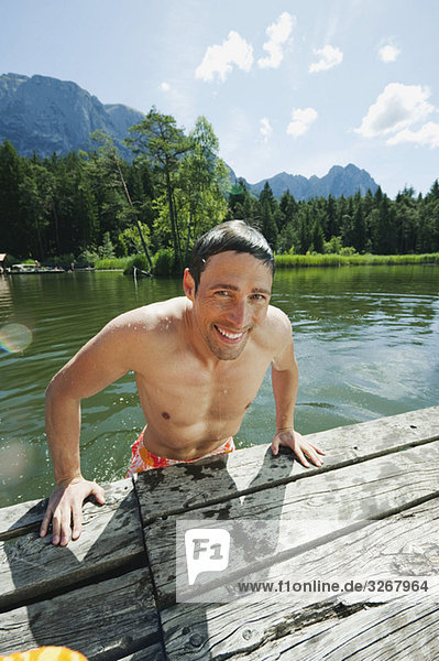 Italy  South Tyrol  Man leaning on jetty  smiling  portrait