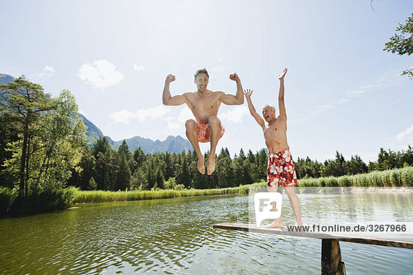Italy  South Tyrol  Men jumping into lake  fooling about