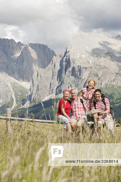 Italy  Seiseralm  Four persons looking at map  portrait