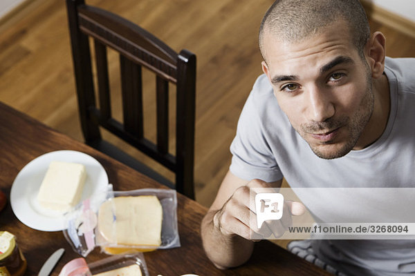 Junger Mann am Tisch beim Frühstück  Porträt