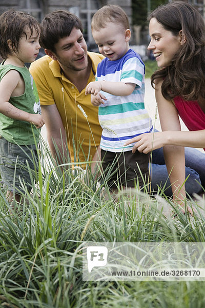 Eltern sehen Marienkäfer auf Jungenarm (1-3)  lächelnd