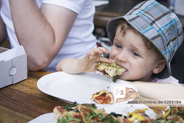 Boy (2-3) eating pizza