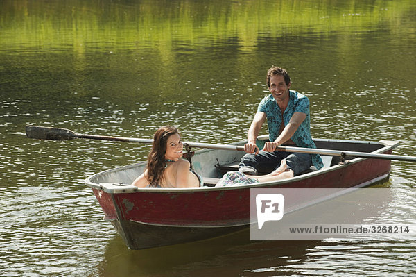 Italy  South Tyrol  Couple rowing boat on lake  smiling  portrait