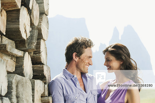 Italien  Südtirol  Seiseralm  Paar vor Holzhaufen stehend  Portrait