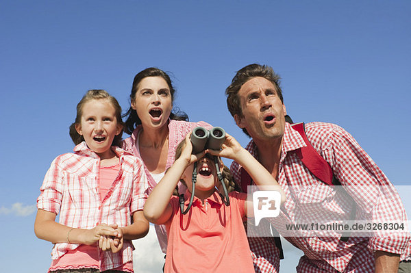 Italy  South Tyrol  Family with children (6-7) (10-11)  girl looking through binoculars  portrait