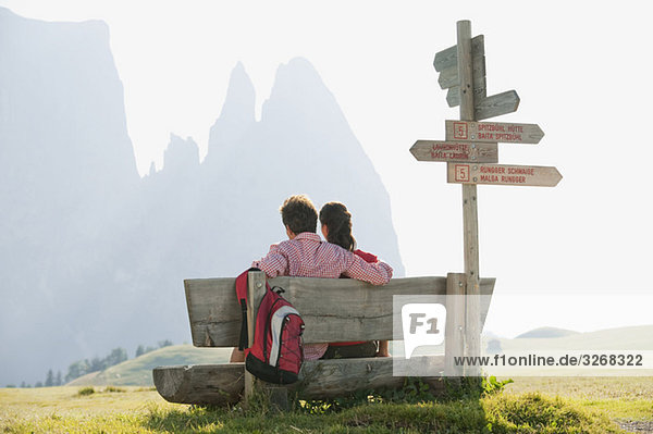 Italy  South Tyrol  Seiseralm  Couple sitting on bench  rear view
