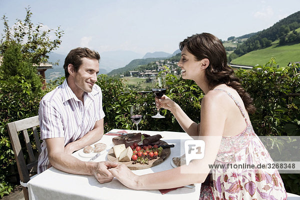 Italien  Südtirol  Seiseralm  Paar im Restaurant Händchen haltend  lächelnd  Portrait
