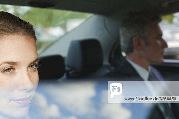 Deutschland  Hamburg  Geschäftsleute sitzen im Auto  schauen aus dem Fenster  Portrait
