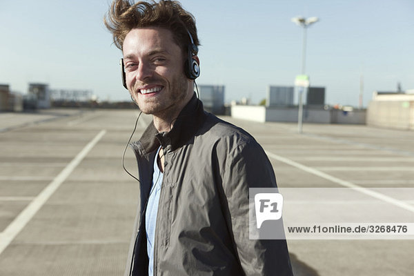 Young man on parking level wearing headphones