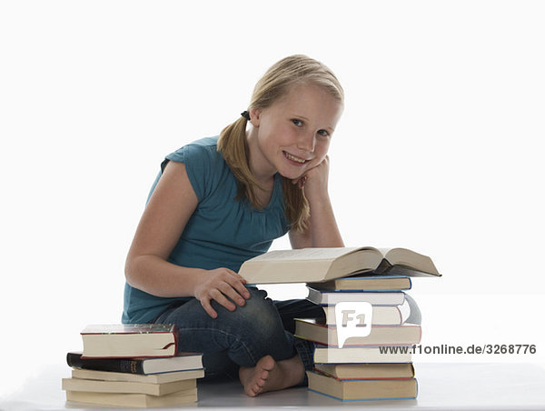 Portrait eines Mädchens (10-11) und gestapelte Bücher