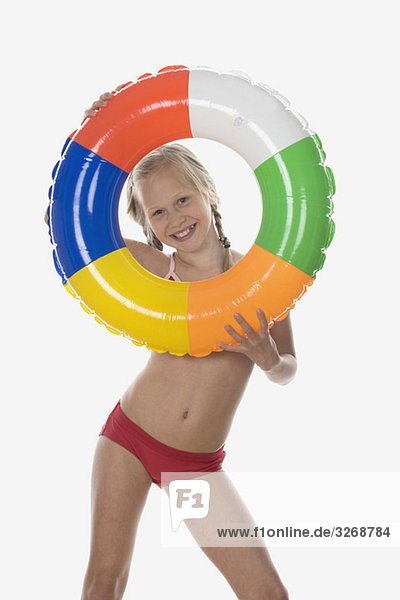 Mädchen (10-11) im Bikini mit Blick durch den schwebenden Reifen  Portrait