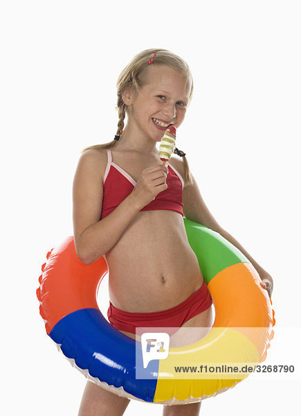 Mädchen (10-11) im Bikini mit Eiscreme  lächelnd  Porträt