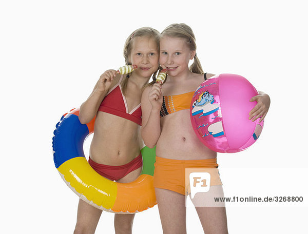 Two girls (10-11) wearing bikini  holding ice cream  portrait
