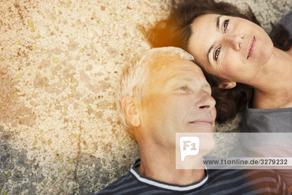 Middle aged couple on rocks with flare