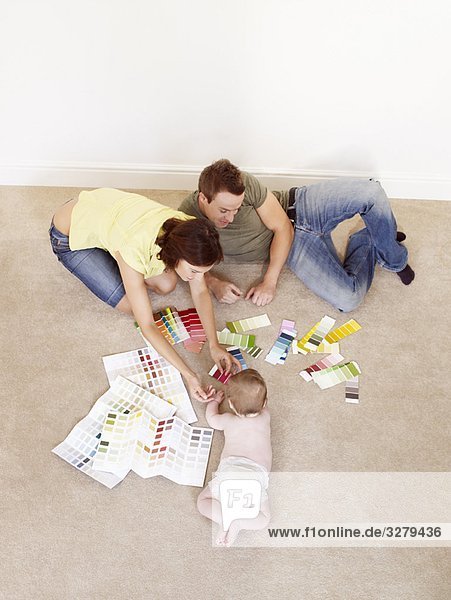 Junge Familie auf dem Boden mit Farbmustern