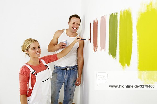 Frau malt Farbmuster an die Wand