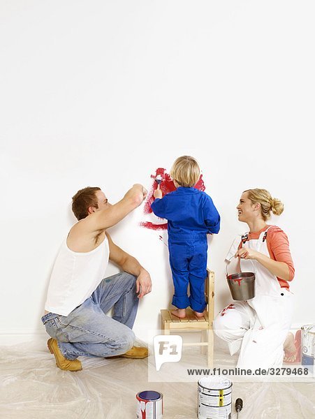 Paar und Kleinkind Jungen malen Wand