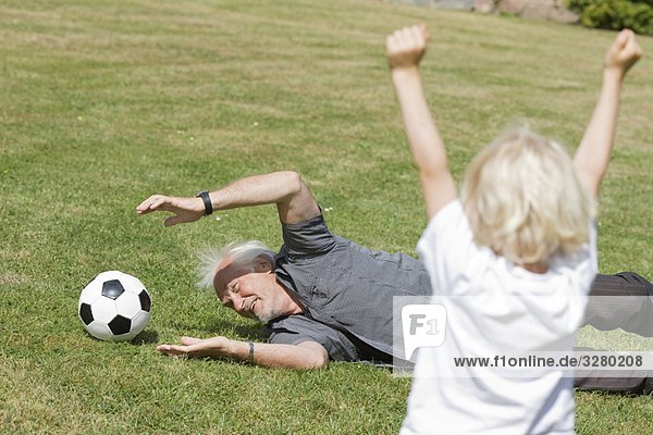 Großvater und Kind beim Fußballspielen