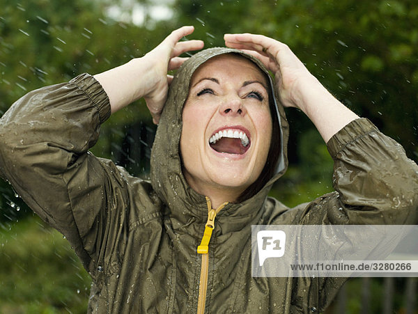 Eine Frau im Regen lächelnd