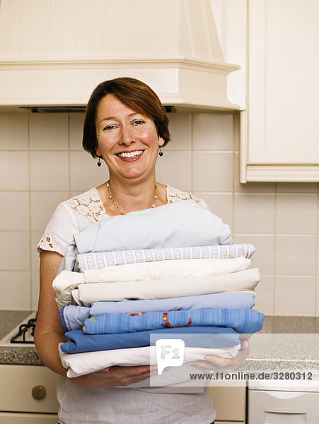 Woman with a pile of ironed washing