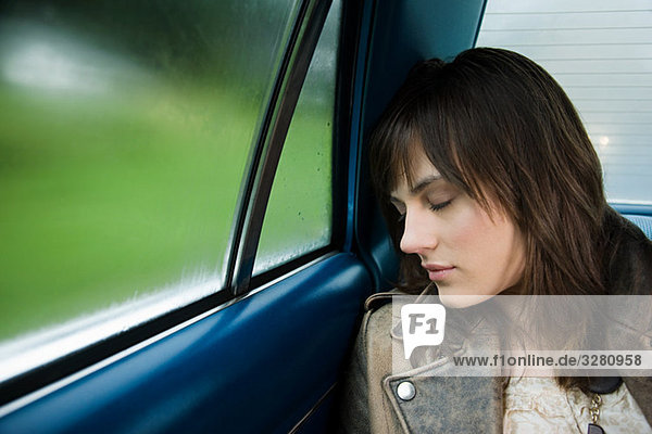 Young woman asleep in car