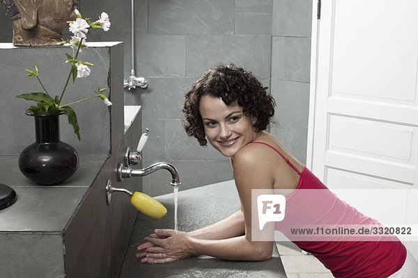 Eine Frau  die ein Waschbecken in einem Wellnessbad benutzt.