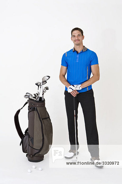 Ein Mann stehend mit Golfausrüstung