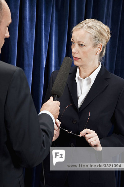 Eine Frau in einem Anzug  die interviewt wird.