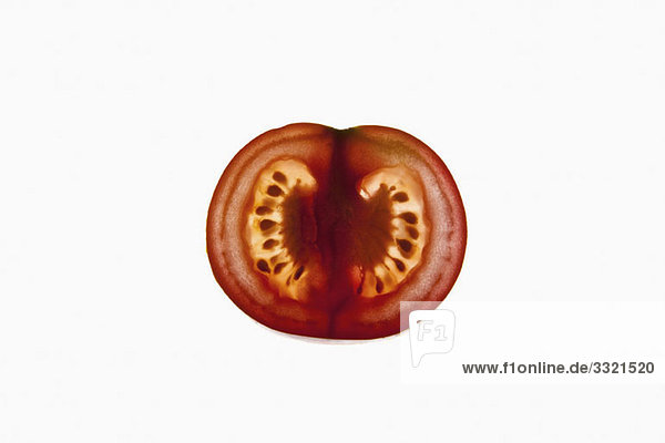 Eine Scheibe einer Bio-Tomate auf einem Leuchtkasten