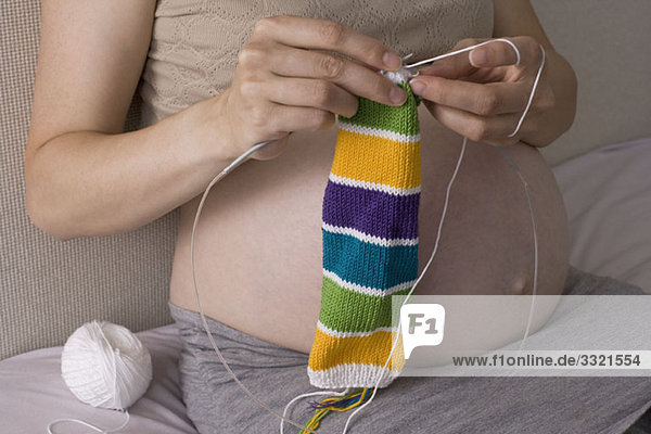 Eine schwangere Frau strickt  Mittelteil