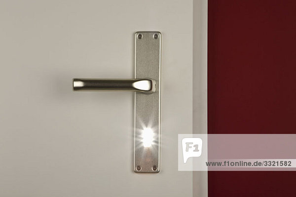 Detail eines durch das Schlüsselloch einer Tür leuchtenden Lichts