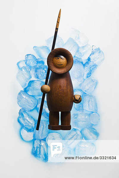 Eine hölzerne Inuit-Figur auf Eiswürfeln
