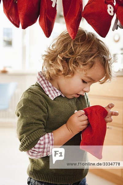 Kleiner Junge inspiziert einen Weihnachtssack