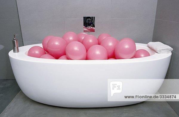 Bad gefüllt mit rosa Luftballons